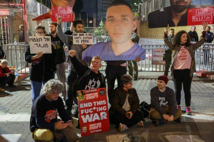 Des proches d'otages israéliens retenus à Gaza brandissent des pancartes appelant à la fin définitive de la guerre et à la libération des otages, lors d'un rassemblement devant le ministère de la Défense à Tel-Aviv, le 8 mars 2025