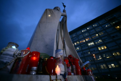 Des bougies sont allumées devant une statue de Jean Paul II à l'extérieur de l'hôpital Gemelli à Rome où le pape François est hospitalisé, le 12 mars 2025