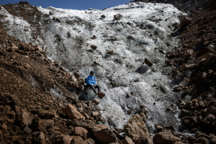 Le guide de randonnée Charles Kibaki Muchiri observe le paysage, assis au pied du glacier Lewis, près du sommet du mont Kenya, dans le parc national du mont Kenya, le 7 mars 2025