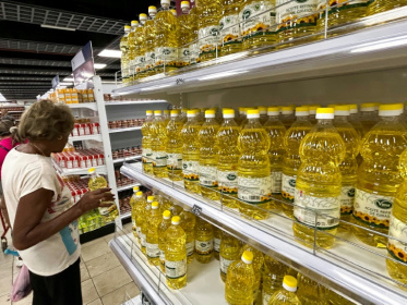 Une cliente regarde un rayon de bouteilles d'huile dans un supermarché où les paiements s'effectuent en dollars, à La Havane, Cuba, le 25 mars 2025