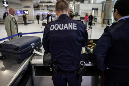 Des douaniers inspectent les bagages de passagers à l'aéroport de Roissy-Charles-de-Gaulle, au nord de Paris, le 21 mars 2025
