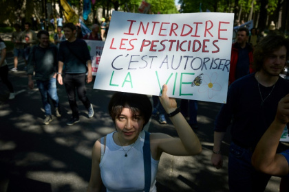 Une manifestante tient une pancarte sur laquelle on peut lire "Interdire les pesticides, c'est permettre la vie" lors d'une marche "Noisy Spring" contre les pesticides à Paris, le 5 avril 2025
