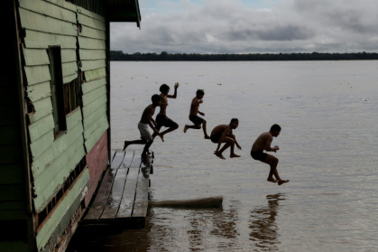 Des enfants plongent dans le fleuve Solimoes près de Marajai, le 16 avril 2025 dans le nord du Brésil - MICHAEL DANTAS (AFP)