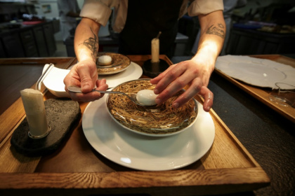 Un sous-chef prépare un plat emblématique du chef étoilé Gilles Goujon, l'œuf de poule "Carrus" pourri à la truffe, au restaurant "Auberge du Vieux Puits" à Fontjoncouse (Aude), le 25 avril 2025 - Valentine CHAPUIS (AFP)