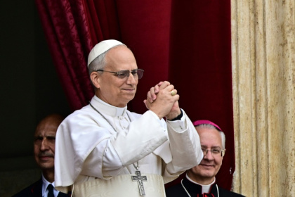 Le pape Léon XIV fait un geste en direction de la foule de fidèles depuis le balcon de la basilique Saint-Pierre au Vatican après la prière Regina Caeli, le 11 mai 2025 - Tiziana FABI (AFP)