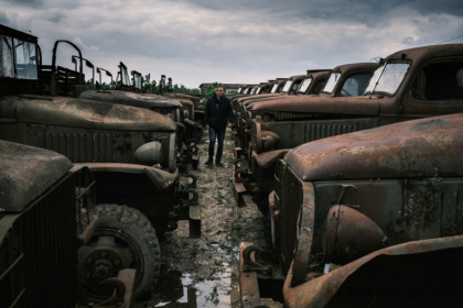 Un visiteur se promène au milieu d'épaves de véhicules de la Seconde guerre mondiale, à La Sône, le 8 mai 2025 en Isère - JEAN-PHILIPPE KSIAZEK (AFP)