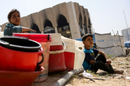Des habitants déplacés de Gaza à un point de collecte d'eau, dans la ville de Gaza, dans le nord du territoire palestinien, le 20 mai 2025 - Bashar TALEB (AFP)