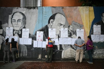 Des électeurs regardent les listes électorales devant un bureau de vote à Caracas, lors des élections pour élire députés et gouverneurs, le 25 mai 2025 au Venezuela - Federico PARRA (AFP)