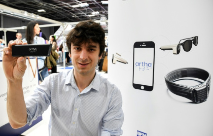 Fondateur français d'Artha France, Rémi Du Chalard présente une mini-caméra qui équipe une paire de lunettes et transmet des données visuelles sous forme de sensations tactiles via une ceinture lombaire à Paris le 10 mai 2024 - Mehdi FEDOUACH (AFP)