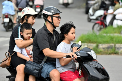 Une famille se déplace en motocyclette, le 4 juin 2025 à Hanoï - Nhac NGUYEN (AFP)