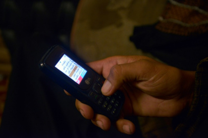 Un membre du personnel de sécurité taliban utilise un téléphone non connecté à Kandahar, le 17 juin 2025 en Afghanistan - Sanaullah SEIAM (AFP)