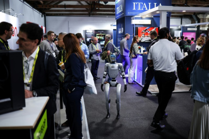 Un robot parmi des visiteurs au salon de l'IA à Londres, le 11 juin 2025 - HENRY NICHOLLS (AFP)