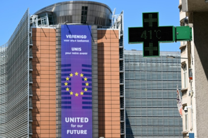 Un thermomètre de pharmacie affiche 41°C, avec en arrière-plan le siège de la Commission européenne, à Bruxelles, le 23 juin 2025 - Nicolas TUCAT (AFP)