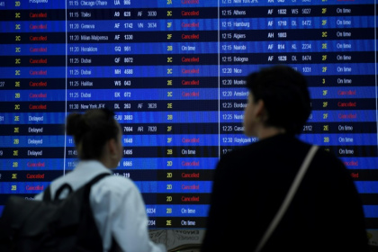 Des voyageurs regardent le panneau des départs du terminal 2 de l'aéroport Roissy-Charles de Gaulle, dans la banlieue nord-est de Paris, le 16 septembre 2022 - JULIEN DE ROSA (AFP)