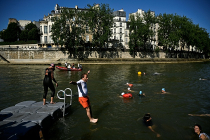 Un riverain se jette à l'eau dans la Seine au bras Marie, le 17 juillet 2024 - JULIEN DE ROSA (AFP)