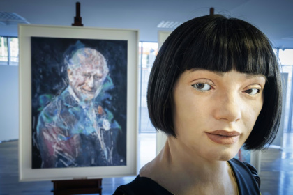 Le robot artiste gynoïde Ai-Da devant le portrait du roi Charles III qu'il a peint, exposé en marge du Sommet mondial AI for Good organisé par l'Union internationale des télécommunications (UIT) à Genève, le 9 juillet 2025 - Valentin Flauraud (AFP)