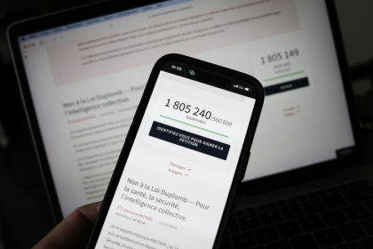 Le site de l'Assemblée nationale sur un écran de smartphone et d'ordinateur indiquant le nombre de citoyens ayant signé la pétition contre la loi Duplomb, le 23 juillet 2025 à Paris - Thibaud MORITZ (AFP)