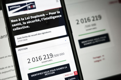 Le site de l'Assemblée nationale sur un écran de smartphone et d'ordinateur indiquant le nombre de citoyens ayant signé la pétition contre la loi Duplomb, le 28 juillet 2025 à Paris - Thibaud MORITZ (AFP)
