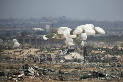 Des palettes d'aide humanitaire sont larguées par un avion militaire au-dessus de Nousseirat, dans le centre de la bande de Gaza, le 18 août 2025 - Eyad BABA (AFP)
