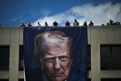 Des ouvriers installent un portrait géant du président américain Donald Trump sur la façade du ministère du Travail à Washington, le 27 août 2025 - Drew ANGERER (AFP)