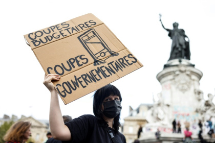 Une manifestante tient une pancarte sur laquelle on peut lire "Coupes budgétaires, coupes gouvernementales" lors d'une manifestation sur la place de la République, à Paris, le 10 septembre 2025 - Ian LANGSDON (AFP)