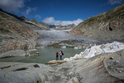 Des touristes devant le glacier du Rhône près de Gletsch, dans les Alpes suisses, le 12 septembre 2025 - Fabrice COFFRINI (AFP)
