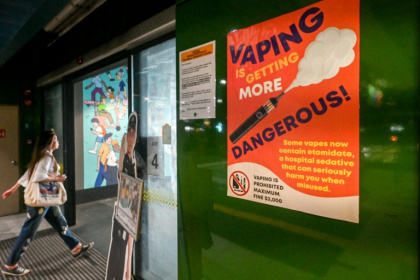 Une affiche mettant en garde contre les dangers liés à l'utilisation des cigarettes électroniques dans une gare routière à Singapour, le 17 septembre 2025 - Roslan RAHMAN (AFP)
