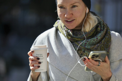 Une femme se déplace dans la rue avec son gobelet de café à New York, le 16 octobre 2025. - ANGELA WEISS (AFP)