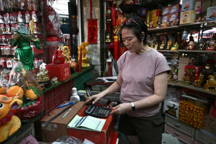 Une commerçante de Bangkok utilise une calculette, le 18 novembre 2025 - Lillian SUWANRUMPHA (AFP)