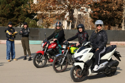 La monitrice Maryam Ghelich (g) et ses élèves Narghes (d), Elham (3e d), Leila et Mona lors d'un cours de conduite de moto dans un cente d'entraînement du nord de Téhéran, le 7 décembre 2025 en Iran - ATTA KENARE (AFP)