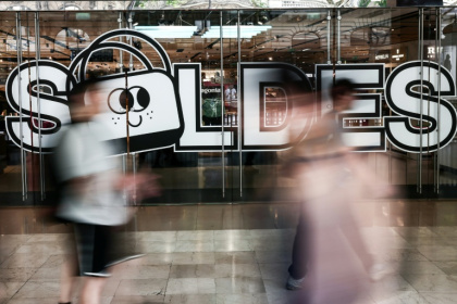 Des passants marchent à proximité de l'entrée d'un centre commercial annonçant les soldes, le 25 juin 2025 à Paris - Thibaud MORITZ (AFP)