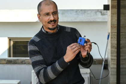 L'universitaire Umair Shahid, cofondateur de Curious Friends of Clean Air (CFCA), tient un appareil de mesure de la qualité de l'air lors d'un entretien avec l'AFP dans son bureau à Islamabad, le 14 janvier 2026 au Pakistan - Asif HASSAN (AFP)