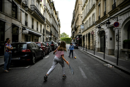 Des enfants jouent au tennis dans une rue de Paris le 21 avril 2020, en plein confinement lié au Covid-19 - Christophe ARCHAMBAULT (AFP)