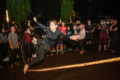 Une membre de la "Play Community", des adultes qui veulent évacuer leur stress, saute par dessus un élastique dans un stade de Jakarta, le 22 mai 2026 - Aditya Irawan (AFP)