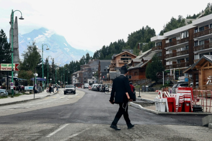 Un homme juif orthodoxe traverse la rue dans la station des Deux Alpes, en Isère, le 19 août 2026 - Alex MARTIN (AFP)