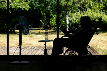 Une personne âgée assise devant un ventilateur en plein épisode de canicule à Pont-Audemer, dans l'Eure, le 12 juillet 2026 - JOEL SAGET (AFP)